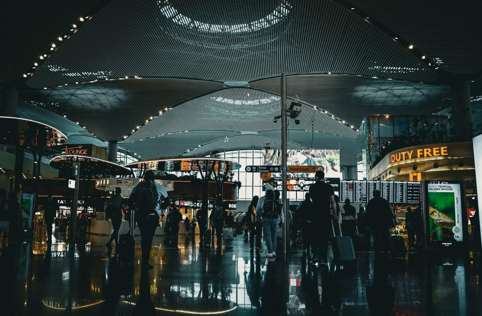 صالة مطار إسطنبول (IST) ليلًا مع المسافرين والمتاجر